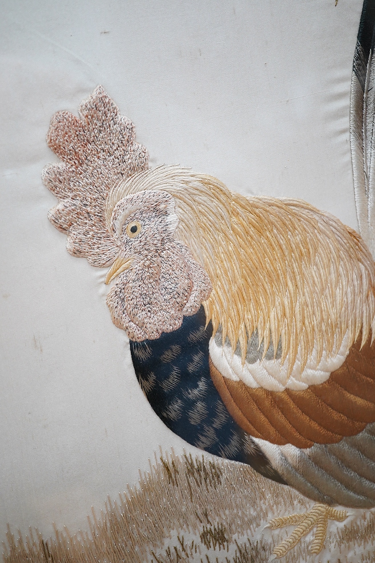 A Victorian fire screen inset with a Japanese cream silk embroidered panel of a cockerel, hen and two chicks, beautifully embroidered with rows of couched silk on the bodies of all the birds, their feathers and faces inc